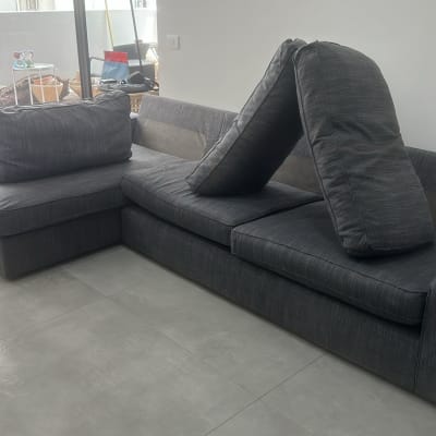 ספה אפורה עם כריות מונחות לניקוי