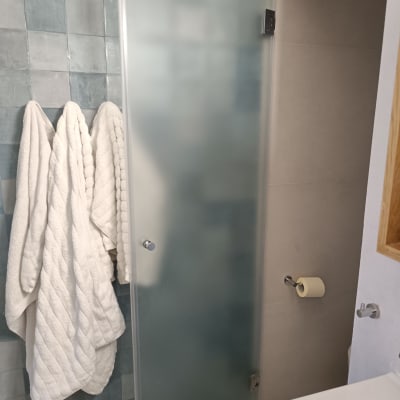 דלת זכוכית חלבית במקלחת עם ידית מתכת