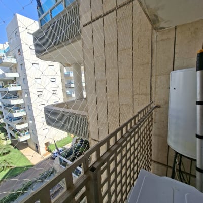 רשת יונים מותקנת על מרפסת בבניין מגורים