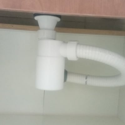 צינור פלסטיק לבן מתחת לכיור במטבח