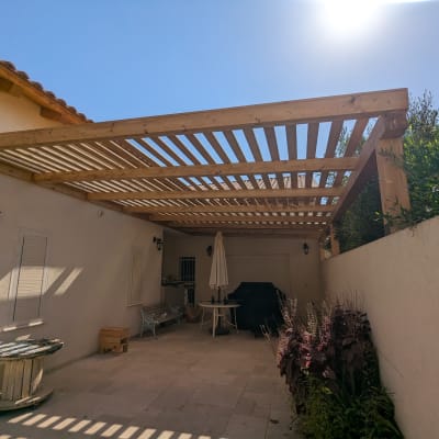 פרגולה מעץ בחצר עם צל ושמש