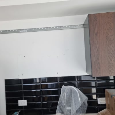 ארון מטבח מותקן על קיר עם אריחים שחורים