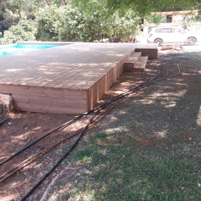 דק עץ בגינה עם מדרגות ועצים מסביב