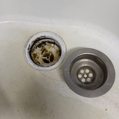 כיור עם ניקוז מלוכלך ומסננת מתכת