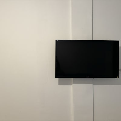 טלוויזיה תלויה על קיר עם כבל חשמל