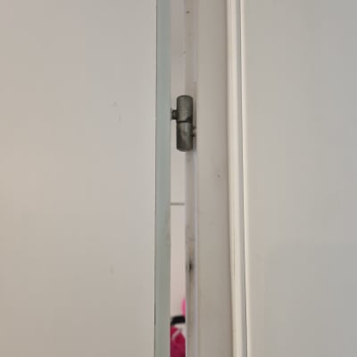 ציר מתכת בדלת לבנה פתוחה מעט