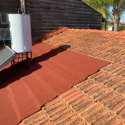 רעפים אדומים על גג עם דוד שמש