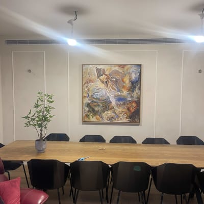 שולחן עץ עם כיסאות, תמונה על הקיר, עציץ קטן