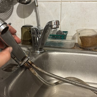 תיקון ברז בכיור מטבח עם כלים מסביב