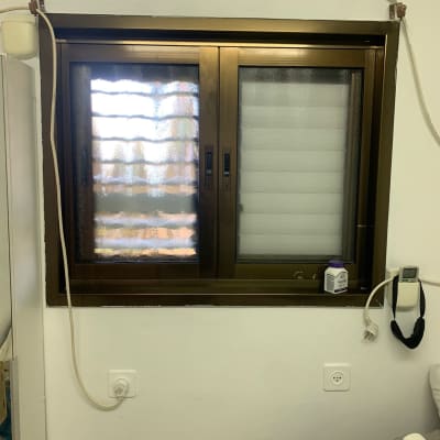 חלון זכוכית עם מסגרת מתכת כהה ותריסים