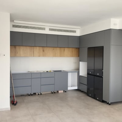 מטבח עם ארונות אפורים ומקרר שחור