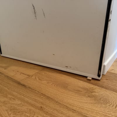 דלת לבנה עם סימני שחיקה על רצפת עץ