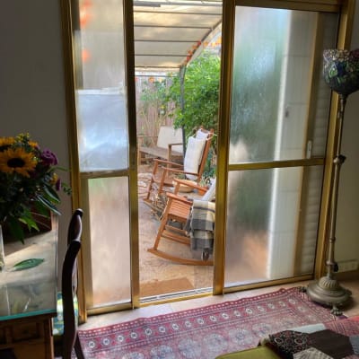 דלת זכוכית עם מסגרת זהב נפתחת לחצר