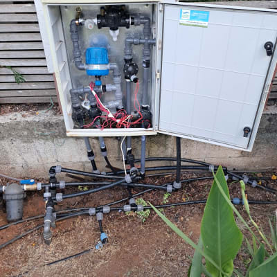 מערכת השקיה עם צינורות ושסתומים בגינה