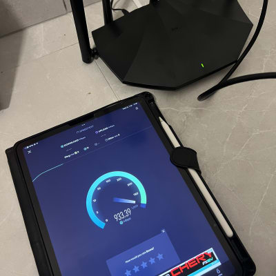 טאבלט עם בדיקת מהירות ליד נתב רשת שחור