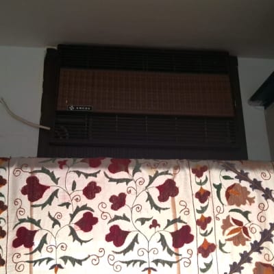 מזגן ישן על קיר עם כיסוי פרחוני