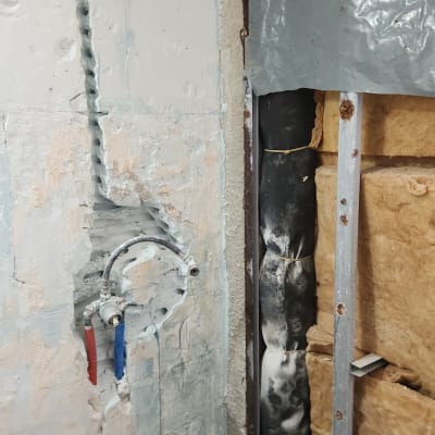 קיר פתוח עם צנרת חשופה ושיפוצים