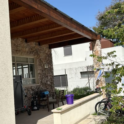 מרפסת עם גג עץ, דלי סגול וצינור מים