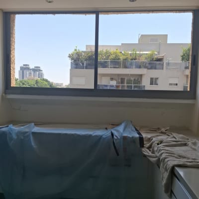 חלון אלומיניום עם נוף לבניינים ועצים