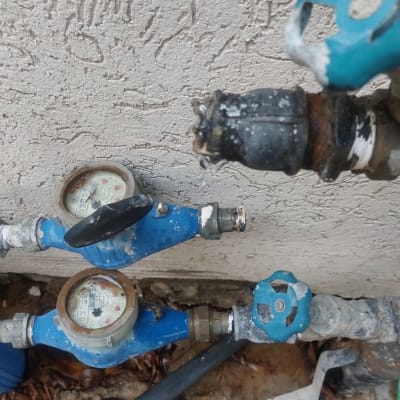 מד מים כחול עם ברזים וצינורות מחוברים