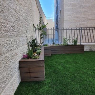 ערוגות עץ עם צמחים ודשא סינתטי