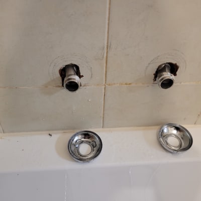 צינורות מים חשופים בקיר אמבטיה