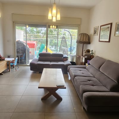 סלון עם ספה, שולחן עץ וחלון גדול