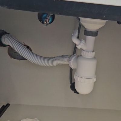 צנרת מתחת לכיור עם מחבר פלסטיק לבן