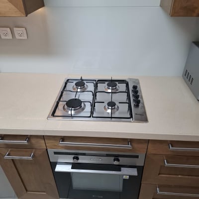 כיריים ותנור במטבח מודרני עם ארונות עץ.