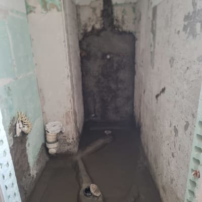 חדר בשיפוץ עם קירות חשופים וצנרת גלויה