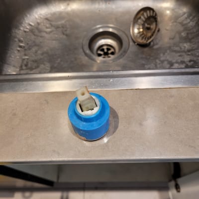 חלק פלסטיק כחול ליד כיור נירוסטה