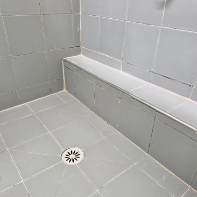 אריחים אפורים במקלחת עם ניקוז ברצפה