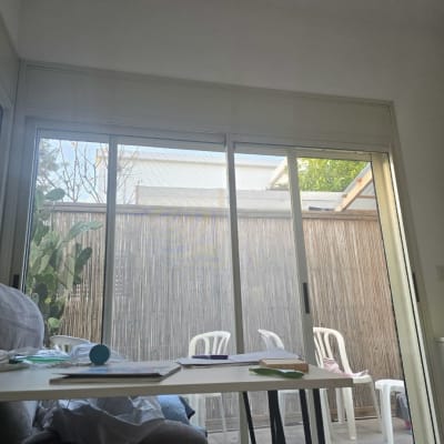 חלון זכוכית גדול עם תריסים נראים מבחוץ