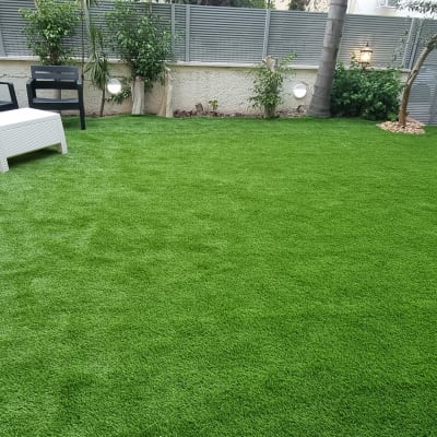 דשא סינתטי עם ריהוט גן ועצים מסביב