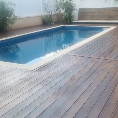 בריכת שחייה עם דק עץ מסביב בגינה