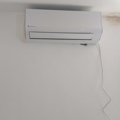 מזגן קיר לבן עם כבל חשמל תלוי