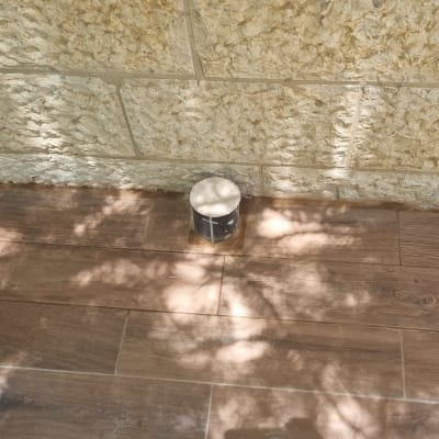 צינור ביוב מכוסה ליד קיר אבן