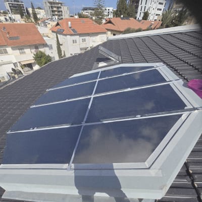 פאנלים סולאריים על גג בניין עם נוף עירוני