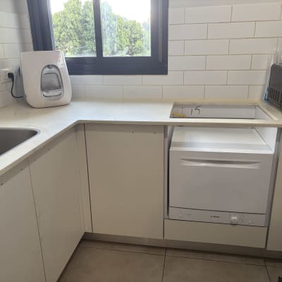 מטבח עם כיור, מדיח כלים ומכשיר על השיש