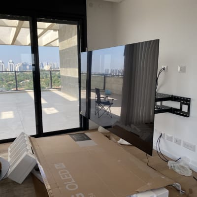 טלוויזיה מותקנת על קיר עם כבלים וכלים מסביב