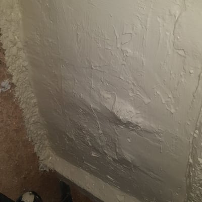 קיר מצופה בחומר בידוד לבן עם מרקם מחוספס