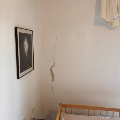 קיר עם סדק ליד מיטת תינוק