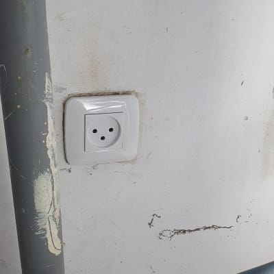 שקע חשמלי בקיר ליד צינור אפור