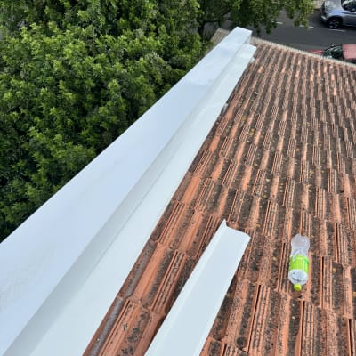 גג רעפים עם לוחות מתכת לבנים ובקבוק פלסטיק