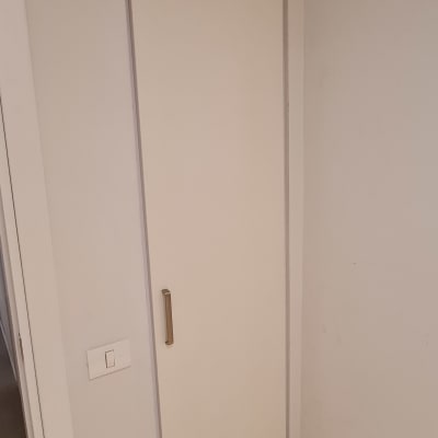 דלת עץ עם ידית מתכת על קיר לבן