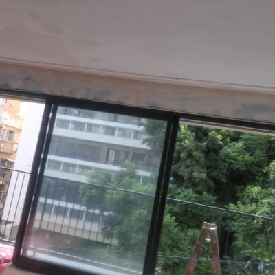 עבודות גבס ושפכטל מעל חלון ויטרינה בחדר שעובר שיפוץ