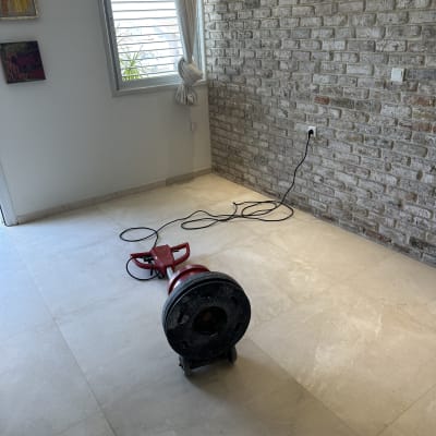 מכונת פוליש אדומה על רצפה בהירה ליד קיר לבנים