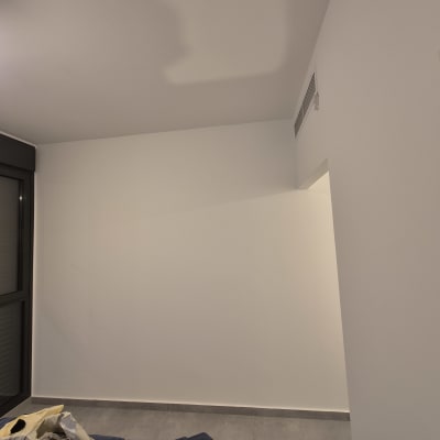 קיר צבוע עם חלון ותאורה בחדר