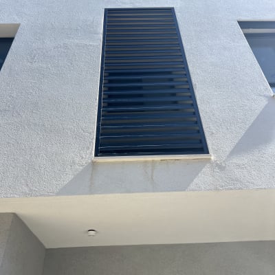 תריסי אלומיניום שחורים על קיר חיצוני לבן