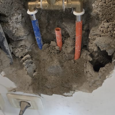 תמונה של צנרת מים בקיר עם חיבורים